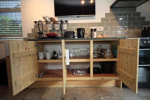 a kitchen with a counter with wooden cabinets at Lynton Lodge Studios in Keswick