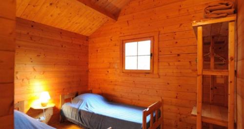 a bedroom in a log cabin with a bunk bed at camping la vallée in Coti-Chiavari