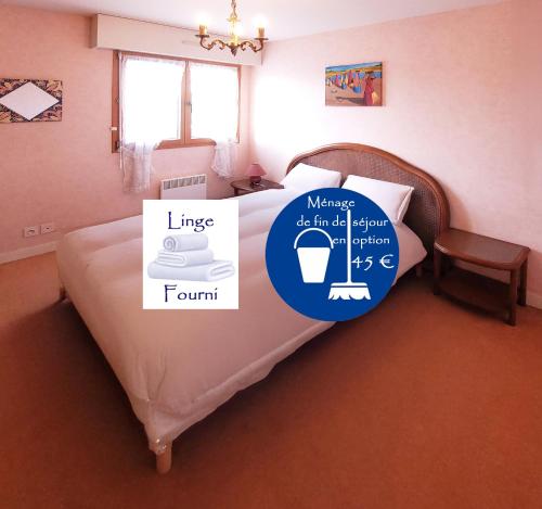 a bedroom with a bed with a sign on it at Le Kervenel - Les Gîtes de la Côte d'Amour in Le Croisic