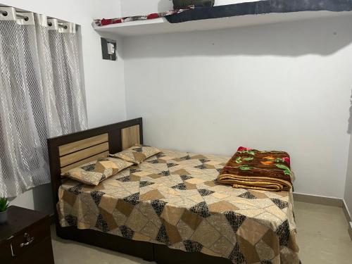 ein Schlafzimmer mit einem Bett mit einer Steppdecke darauf in der Unterkunft Tulips villa in Mānantoddy