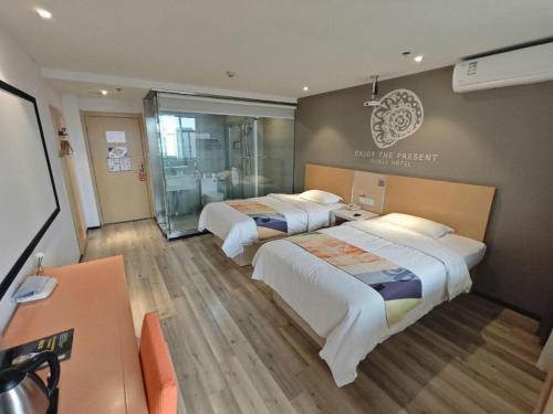 a hotel room with two beds and a desk at Shell Nanjing Jiangning District University City Hotel in Chunhua