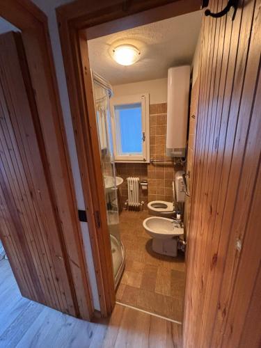a bathroom with a toilet and two sinks in it at L'Atelier du Temps - Il Sogno di GI in Courmayeur