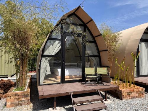 un gazebo con letto e sedie in cortile di Nadi Glamping Suites a Perai