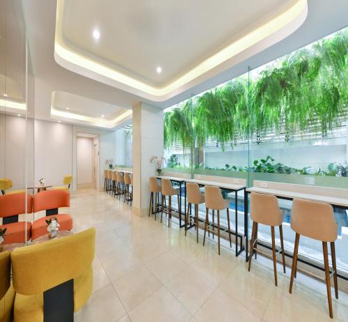 a restaurant with a bar with chairs and tables at Centre Point Plus Hotel Pratunam in Bangkok