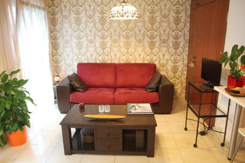 a living room with a red couch and a coffee table at Tiffany's Apartment in Las Palmas de Gran Canaria