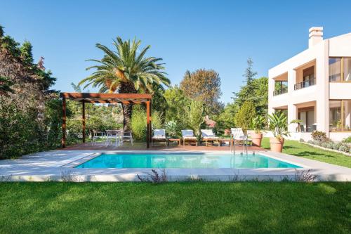 een zwembad in de tuin van een huis bij Coral Tree Luxury Villa in Ialyssos