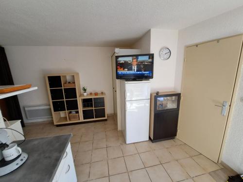 una cucina con TV a parete e frigorifero di Joli t2 valras plage a Valras-Plage