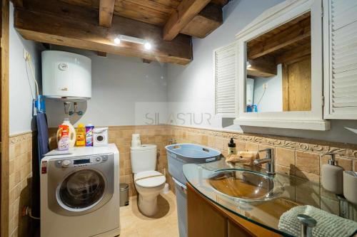 a bathroom with a washer and a sink and a toilet at La Casina del Alba in Campiellos