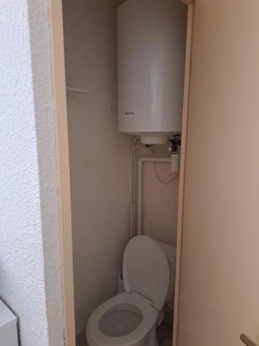 a bathroom with a toilet with a cabinet above it at Joli t2 valras plage in Valras-Plage