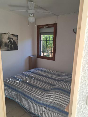 a bed in a room with a window at Joli t2 valras plage in Valras-Plage