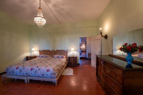 - une chambre avec un lit et un vase orné de fleurs dans l'établissement Casa Dolcetto, à Tagliolo Monferrato