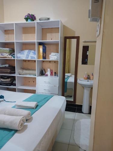 a room with a bed and a sink and a mirror at Serenity in Disguise in Mombasa
