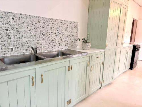 a kitchen with white cabinets and a sink at Sunrise & Sunset Haven in Mossel Bay