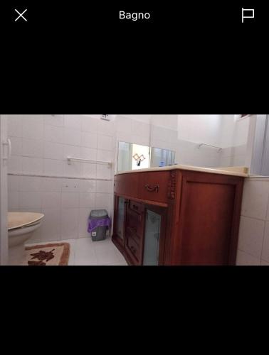 a bathroom with a wooden cabinet and a sink at Florina Appartment in Capo dʼOrlando