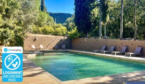 a swimming pool with blue lounge chairs next to it at Camping 3 étoiles - Piscine - ccbccbe in Sartène