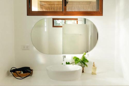 a bathroom with a white sink and a mirror at Casa De Amor Lambug in Badian