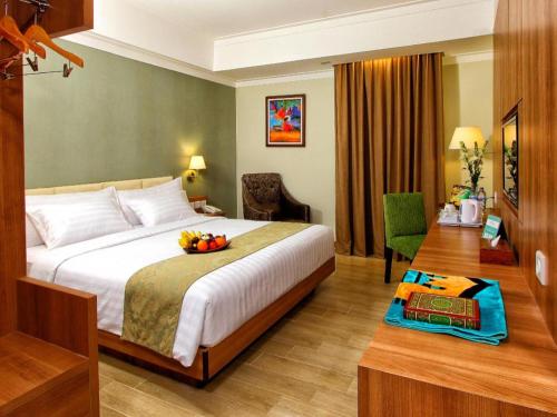 una camera d'albergo con un letto e un cesto di frutta. di Horison Aziza Solo a Solo