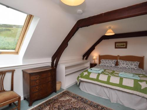 een slaapkamer met een bed, een stoel en een raam bij 2 Bed in Drumelzier CA366 in Drummelzier