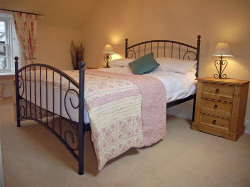 een slaapkamer met een bed en een houten nachtkastje bij 2 Bed in Birnam CA266 in Birnam