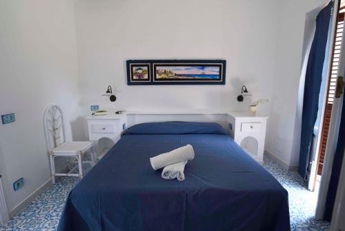 Un dormitorio con una cama con una colcha azul. en Pietra Pomice Hotel, en Lipari
