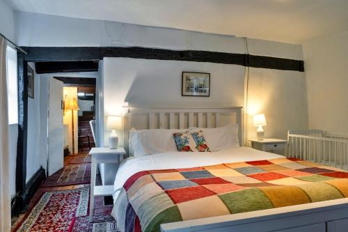 a bedroom with a large bed with a colorful blanket at Finest Retreats - Cricketers Cottage in Alderley