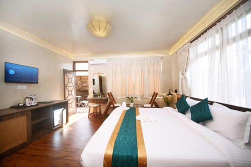 a hotel room with a large bed and a living room at Tibet Boutique Hotel Annex in Kathmandu