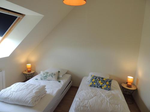 twee bedden in een kleine kamer met twee lampen bij Agapanthe blanche in La Garde