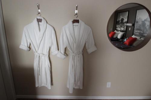 two white robes hanging on a wall next to a mirror at Koreana in Decorah in Decorah