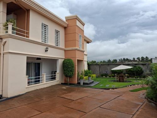 a house with a patio and a yard at Tia Vahine - Navette Gratuite Aéroport H24 in Ivato