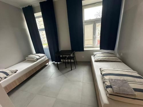 two beds in a room with two windows at StarBal in Radom