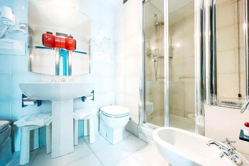 a bathroom with a sink and a toilet and a shower at Hotel Britannia in Genova