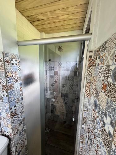 a shower stall in a bathroom with mosaic tiles at Chalé na beira da lagoa com vista in Imbituba