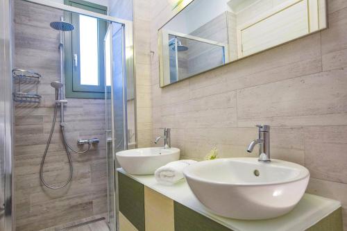 un bagno con lavandino e doccia di Villa Cypressa by Villa Plus a Kalamitsi