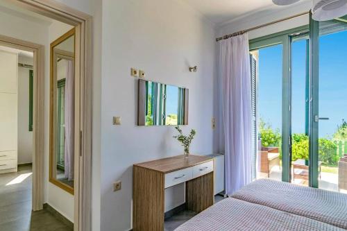 una camera da letto con un letto, una scrivania e una finestra di Villa Cypressa by Villa Plus a Kalamitsi