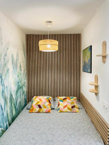 a bedroom with a bed and two pillows at Appart'Hotel au Pradet in Le Pradet