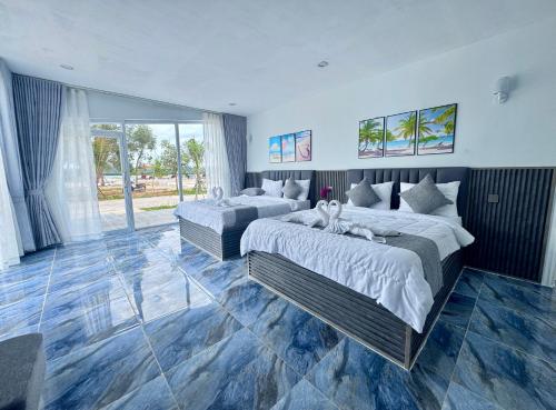Un dormitorio con dos camas y una gran ventana. en MNResort, en Koh Kong