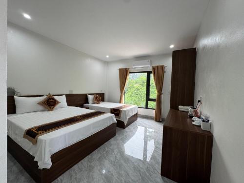 une chambre d'hôtel avec deux lits et une fenêtre dans l'établissement Vạn Xuân Royal Hotel, à La Phù