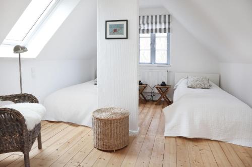 two beds in a room with white walls and wooden floors at Kembser Kate - Ostholstein - NEU! in Behrensdorf