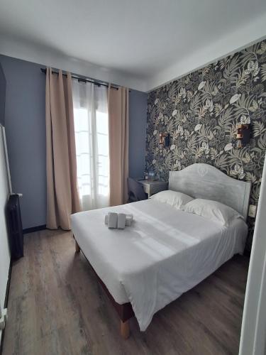 a bedroom with a large white bed with a floral wallpaper at FASTHOTEL Le Costabonne in Prats-de-Mollo-la-Preste