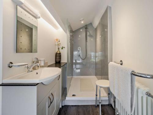 een witte badkamer met een wastafel en een douche bij 5 Bed in Machynlleth 92513 in Machynlleth