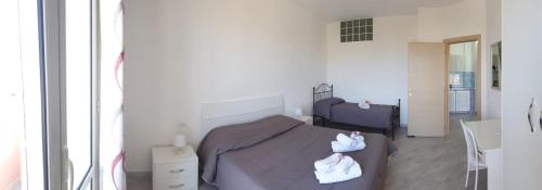 a bedroom with a bed with two white towels on it at Lampedusa Centro Camere&Appartamenti in LMP