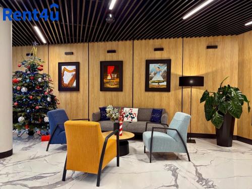 ein Wohnzimmer mit einem Weihnachtsbaum, einer Couch und Stühlen in der Unterkunft Apartamenty Nad Zatoką in Olsztyn