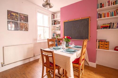 a dining room with a table and chairs and a chalkboard at Exesixteen in Exeter