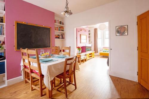 a dining room with a table and a chalkboard on the wall at Exesixteen in Exeter