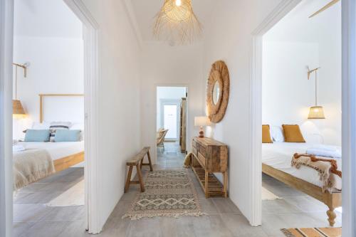 a white bedroom with a bed and a mirror at Casa Ladeira in Loulé