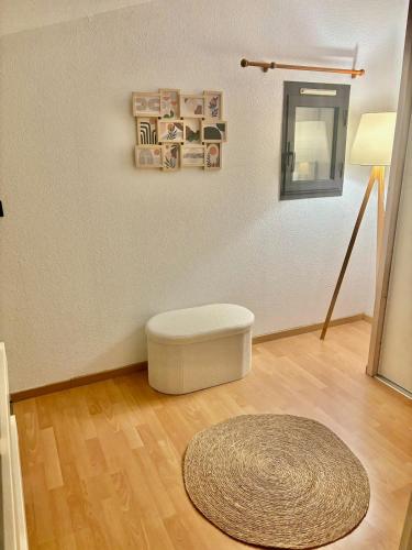 a room with a white ottoman and a rug at Appartement 3 chambres - 8 couchages in Six-Fours-les-Plages