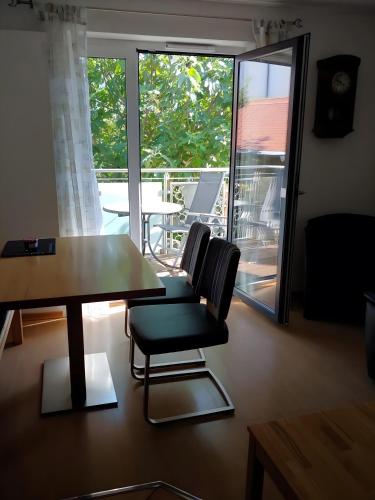una sala da pranzo con tavolo e sedie e un balcone di Ferienwohnung Dauth a Kressbronn am Bodensee