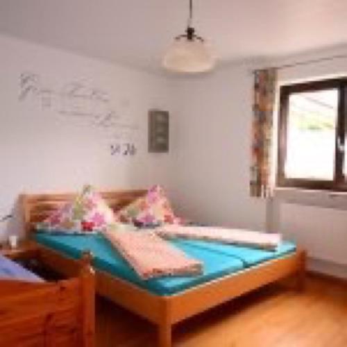 una camera con un letto, una finestra e un tavolo di Ferienwohnung Dauth a Kressbronn am Bodensee