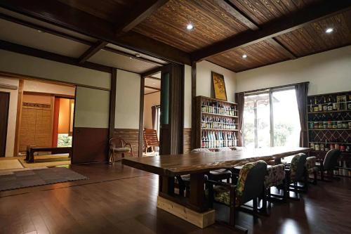 おこさま連れ限定一棟貸し的場邸 : مكتبة بها طاولة وكراسي خشبية كبيرة