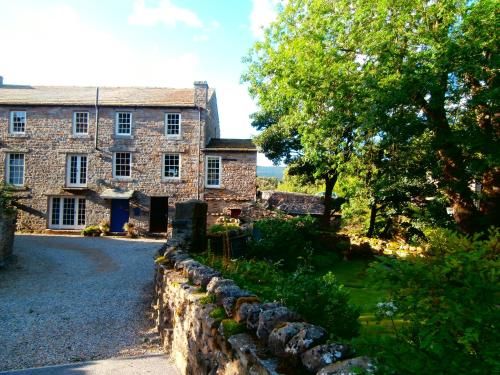 an old stone house with a stone fence in front of it at Riverside Bed & Breakfast in Bainbridge